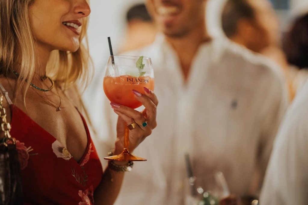 Guests holding Islands8 signature cocktails at an event